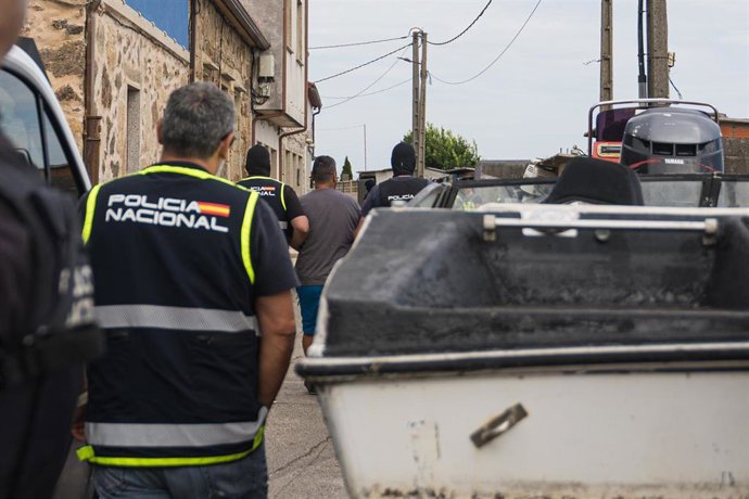 Varios agentes de la Policía Nacional se llevan a un detenido en una operación antidroga, a 22 de agosto de 2026, en A Pobra do Caramiñal, A Coruña, Galicia (España). 