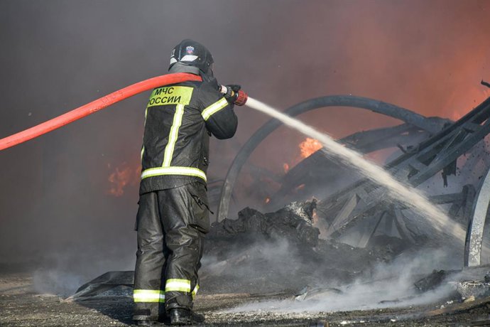 RÚSSIA, REGIÃO DE KRASNODAR – 12 DE AGOSTO DE 2026: Um funcionário do Ministério de Emergências da Rússia apaga um incêndio em um depósito de produtos plásticos na vila de Lenina, a sudeste de Krasnodar.  O incêndio, que abrangeu uma área de 2,2 mil m, f