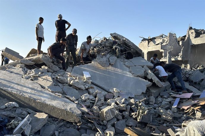 August 25, 2026, Deir Al-Balah, Gaza, Palestinian Territory: Palestinians inspect destruction caused by an Israeli strike that hit residents' homes, displacement tents and a food aid warehouse in Deir el-Balah, in the central Gaza Strip, on August 25, 202