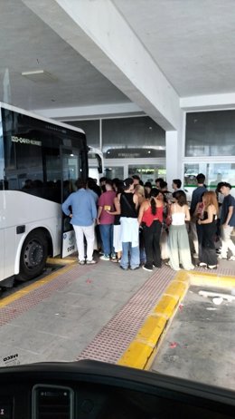Un grupo jóvenes espera para subir a un autobús en la estación de Martos.