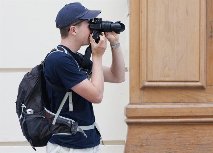 Archivo - Un turista toma fotografías en la Puerta del Sol, a 1 de junio de 2023, en Madrid (España). 
