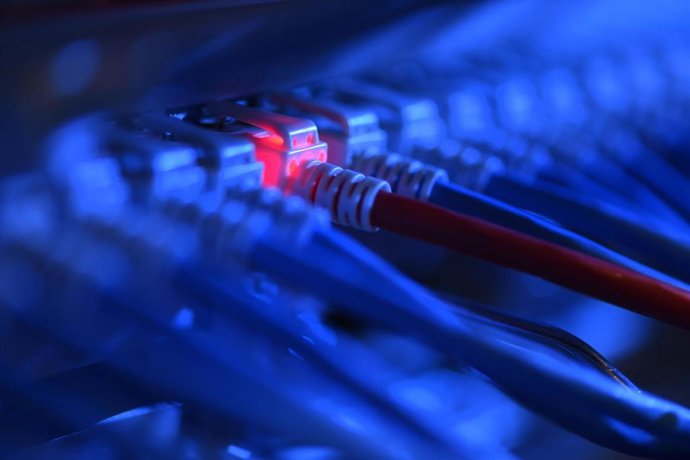 Archivo - FILED - 16 October 2014, Baden-Wuerttemberg, Friedrichshafen: A network cable plug glows red at the network control center of a company. 