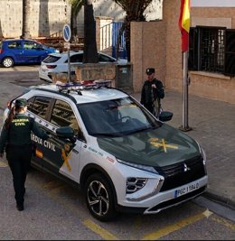 Agentes de la Guardia Civil junto a un vehículo del cuerpo.