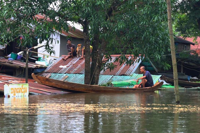 Residentes permanecen dentro de una casa inundada en el municipio de Ngathaingchaung, región de Ayeyarwady, en Birmania