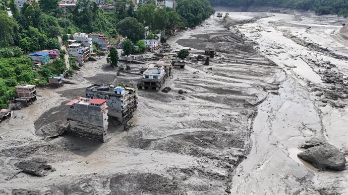 26 de agosto de 2026, Nepal, Nuwakot: Uma vista aérea mostra prédios e infraestrutura danificados ao longo do rio Trishuli, que está cheio, após uma enorme enchente repentina provocada por uma avalanche de gelo e rochas na parte alta do rio Lhende, no lad