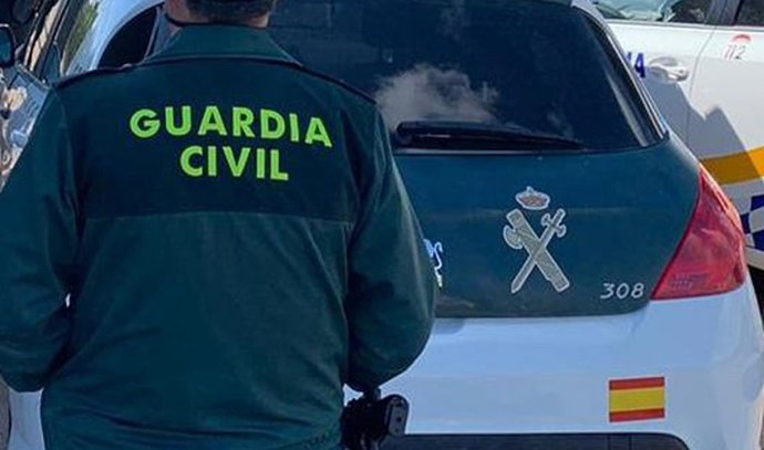 Archivo - Imagen de archivo de un agente de la Guardia Civil junto a un vehículo oficial