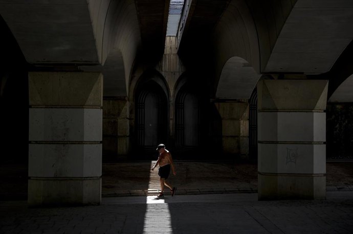 Archivo - Un hombre camina sin camiseta en el antiguo cauce del río Turia, a 12 de agosto de 2022, en Valencia