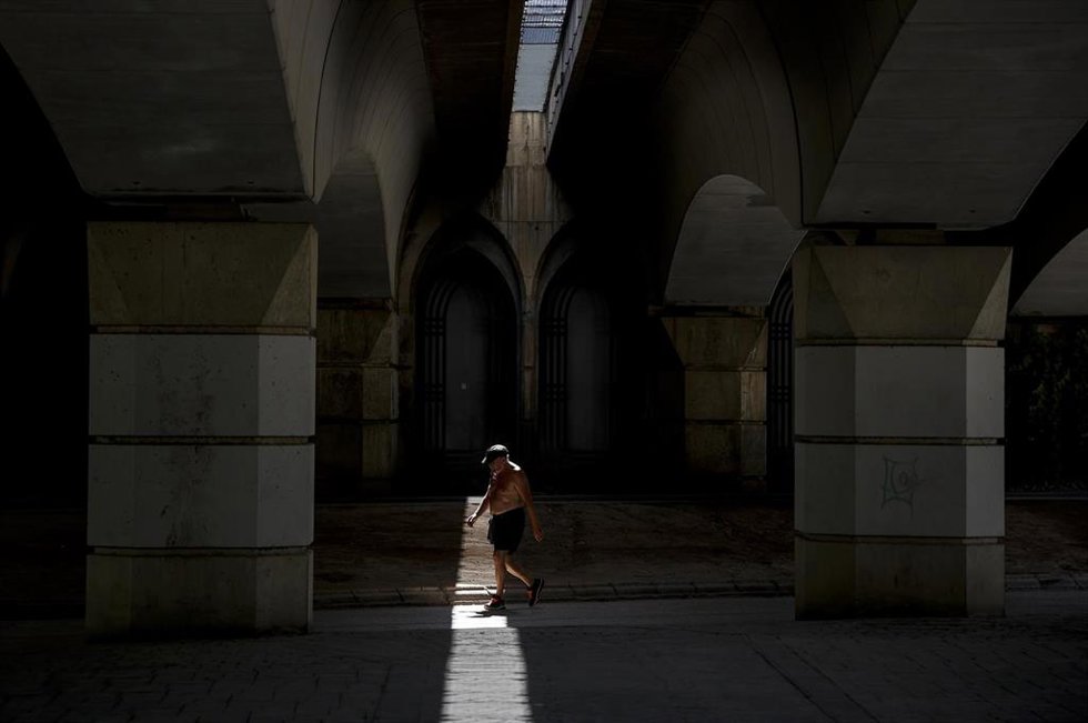 Archivo - Un hombre camina sin camiseta en el antiguo cauce del río Turia, a 12 de agosto de 2022, en Valencia