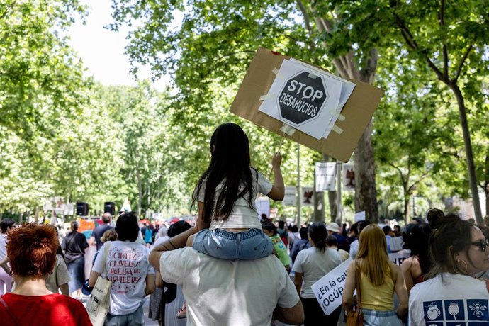 Archivo - Manifestantes portan pancarta con lema 'Stop desahucios'.