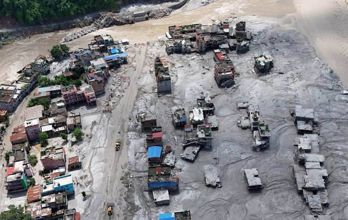 27 de agosto de 2026, Nepal, Nuwakot: Uma imagem aérea mostra prédios soterrados por lama e escombros após enchentes repentinas em Devighat, no município de Bidur, distrito de Nuwakot. As enchentes, provocadas por um colapso glacial e um fluxo de escombro