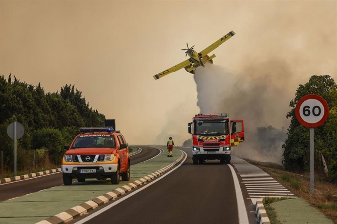 Un avión y coches de bomberos durante las labores de extinción de un incendio forestal, a 27 de agosto de 2026, en la Gola de Pujol, El Saler