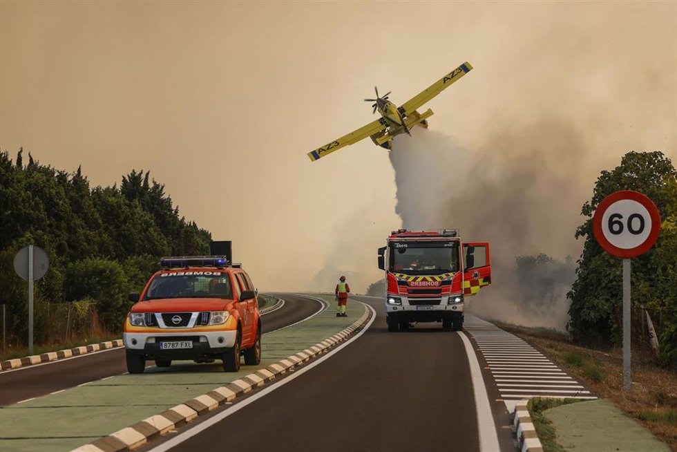 Un avión y coches de bomberos durante las labores de extinción de un incendio forestal, a 27 de agosto de 2026, en la Gola de Pujol, El Saler