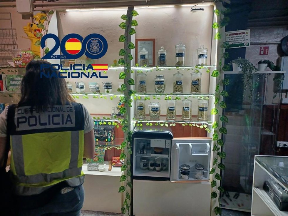 Una agente de la Policía junto al falso local de venta de marihuana con fines terapéuticos
