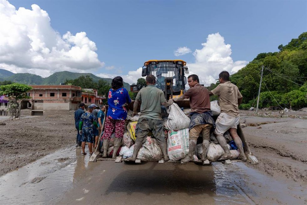 Un vehículo traslada a varias personas tras una gran riada repentina en Nuwakot, Nepal.
