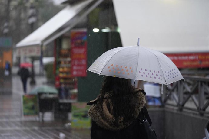 Archivo - Una persona se protege de la lluvia con un paraguas. A 03 de marzo de 2025, en Sevilla (Andalucía, España). 