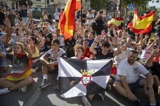 Varias personas durante una manifestación para protestar por la situación provocada por la llegada masiva de migrantes, a 27 de agosto de 2026, en Ceuta (España). Los manifestantes han tratado de impedir el acceso de los voluntarios de Cruz Roja que repar