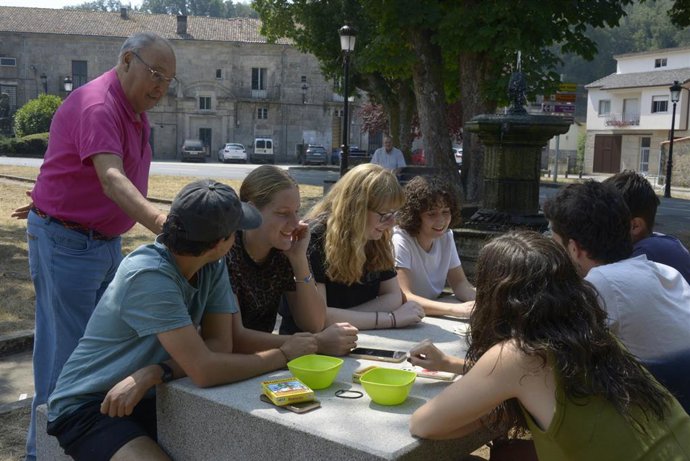 Varios jóvenes participan en una partida de cartas (timba) en la Plaza Mayor de Montederramo, 28 de agosto de 2026, en Montederramo, Ourense, Galicia (España). 