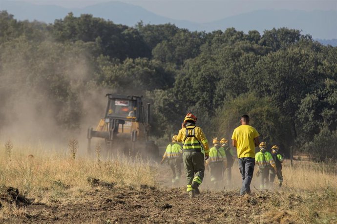 Archivo - Peones forestales y un buldócer realizan labores de extinción, a 21 de julio de 2026, en Brieva, Segovia, Castilla y León (España). El Cecopi de Segovia ha ordenado la evacuación de ochos municipios, Tenzuela, Losana de Pirón, Carrascal de la Cu
