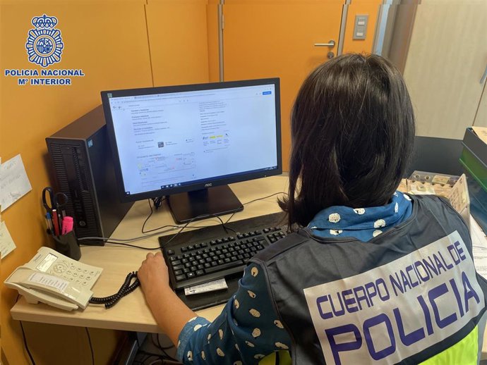 Archivo - Una agente de Policía frente a un ordenador, en una imagen de archivo.