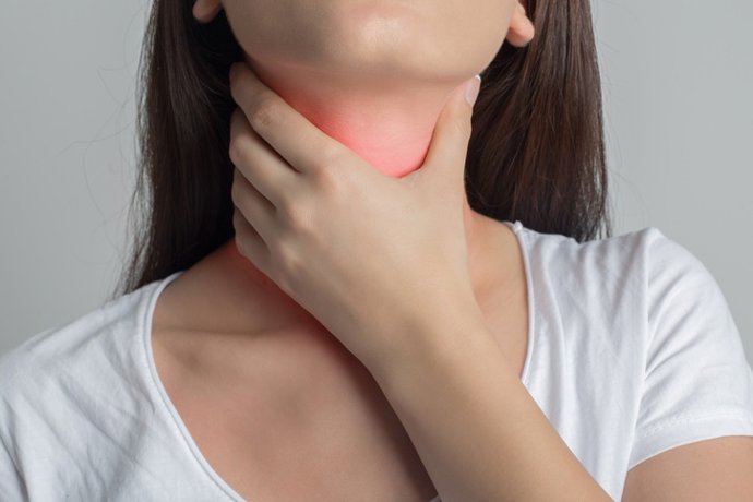 Archivo - Woman holds her throat