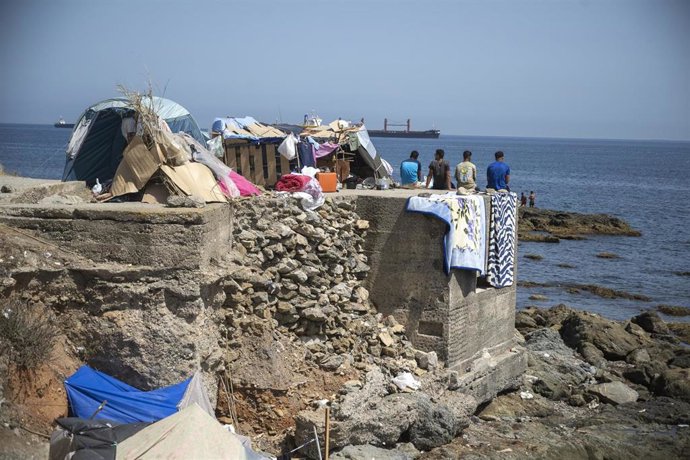 Varios inmigrantes acampados en una playa, a 31 de agosto de 2026, en Ceuta (España).