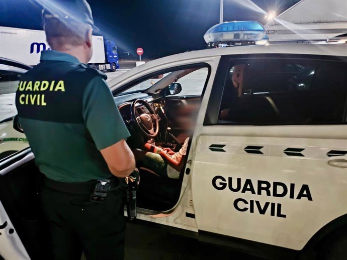 Un agente de la Guardia Civil junto a un vehículo oficial.