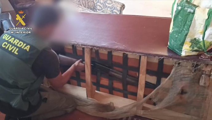 Un agente de la Guardia Civil encuentra un arma durante un registro de la operación contra el tráfico de drogas en el norte de Cáceres