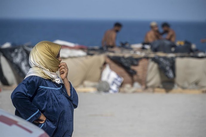 Una persona migrant assentada en la platja del Trampolí, a 31 d'agost del 2026, a Ceuta (Espanya). 