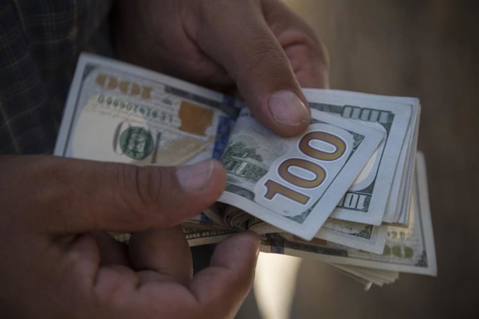 Archivo - Arquivo - 1º de julho de 2019 - Sanandaj, Curdistão, Irã - Um cambista iraniano curdo sunita conta notas de dólar americano enquanto está parado à beira da rua em Sanandaj, na província do Curdistão, no Irã. Sanandaj é a capital da província do 
