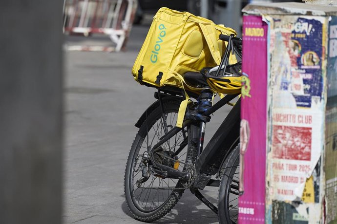 Archivo - Un repartidor de Glovo en bicicleta por una calle.