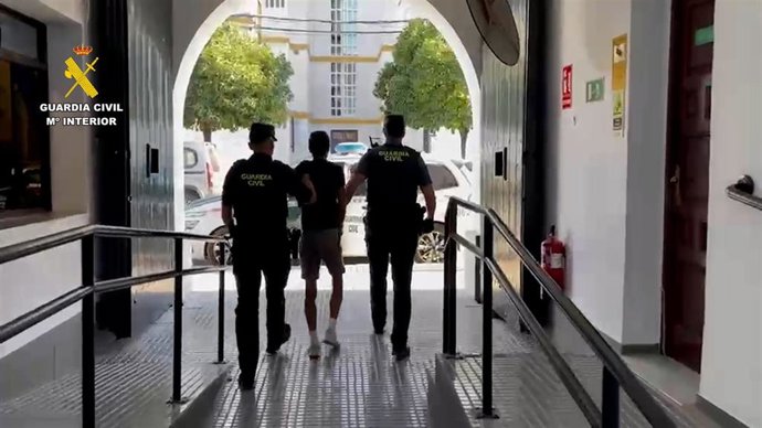 Dos agentes de la Guardia Civil junto al detenido.
