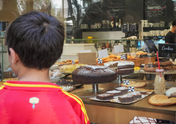 Un niño observa una vitrina con productos que llevan una banderita de Ceuta como muestra de apoyo y visibilidad del sector hostelero