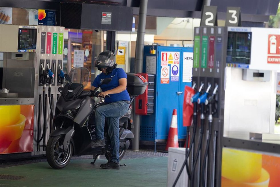 Una persona reposta el combustible de su moto en una gasolinera