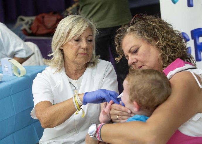 Archivo - Una enfermera administra la vacuna intranasal contra la gripe a un niño en un colegio. Foto de archivo
