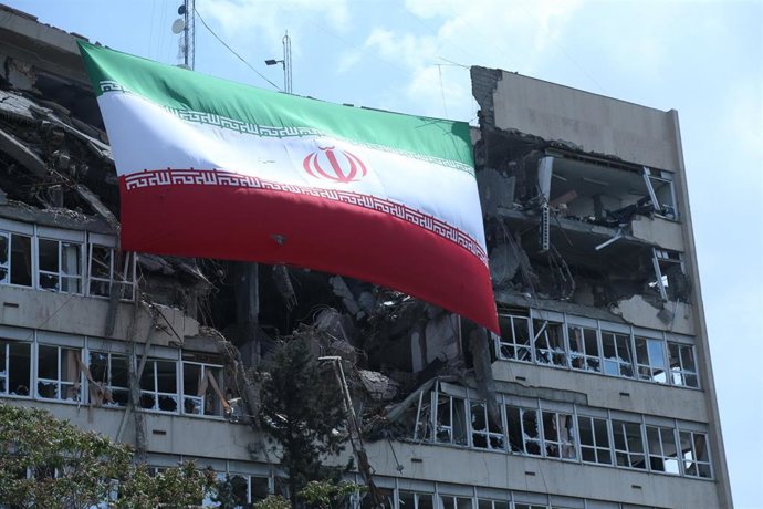 Archivo - Fotografía tomada el 20 de abril que muestra una bandera de Irán colgada de un edificio dañado por los ataques de Estados Unidos e Israel en Teherán, Irán