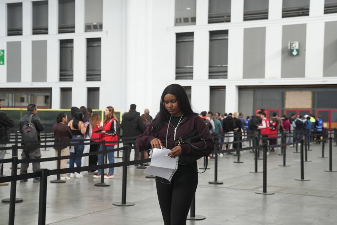 Archivo - Una mujer revisa sus papeles en el pabellón 2 del recinto de Montjuïc de Fira de Barcelona, a 6 de mayo de 2026, en Barcelona, Catalunya (España). El Ayuntamiento de Barcelona ha habilitado desde hoy el pabellón 2 del recinto Montjuïc de Fira de