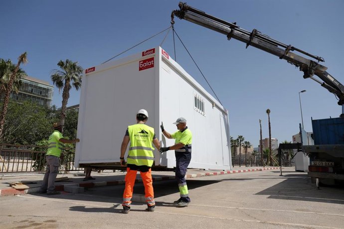 Archivo - Varios operarios realizan tareas de limpieza y de montaje.