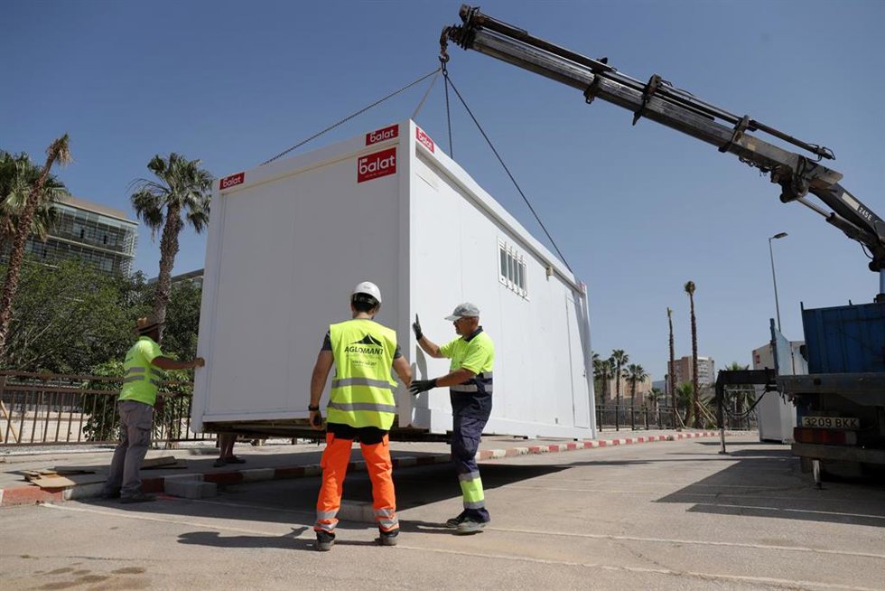 Archivo - Varios operarios realizan tareas de limpieza y de montaje.
