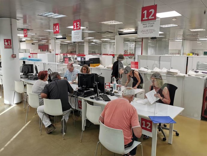 Archivo - Personas en una oficina municipal para realizar trámites.