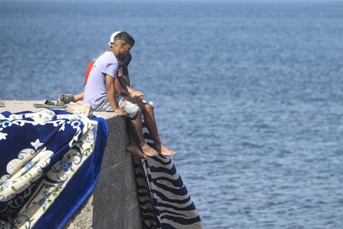 Varios migrantes asentados en la playa del Trampolín, a 31 de agosto de 2026, en Ceuta (España). La playa del Trampolín, vuelve a concentrar un gran número de chabolas improvisadas pese al traslado previo de personas migrantes a otros espacios habilitados