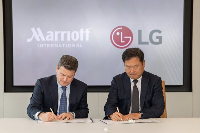 Drew Pinto, vicepresidente ejecutivo y director de ingresos y tecnología de Marriott International, y Don Kwack, presidente y consejero delegado de LG Electronics Norteamérica, firman el acuerdo estratégico