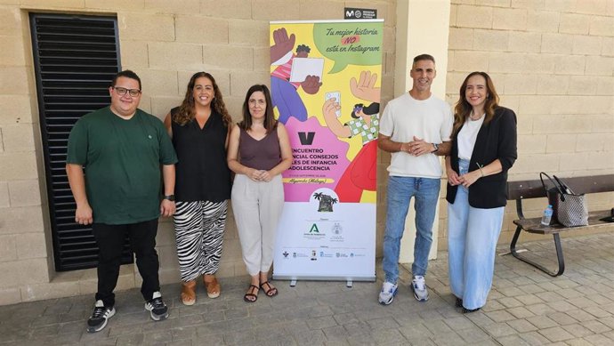 La delegada territorial de Servicios Sociales, Familias e Igualdad de la Junta de Andalucía en Málaga, Laura Valle, junto al cartel del quinto Encuentro Provincial de Consejos Locales de Infancia y Adolescencia.