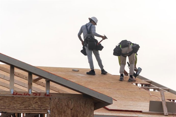 Archivo - Arquivo – 29 de janeiro de 2026, Mesa, Arizona, EUA: Dois operários da construção civil instalam a cobertura do telhado em uma casa de dois andares em construção na região metropolitana de Phoenix. O Arizona foi o estado que mais criou empregos 