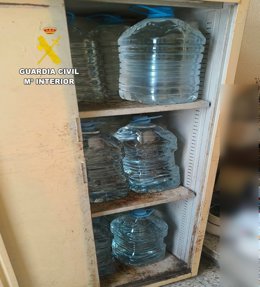Recipientes de orujo ilegal almacenados en condiciones insalubres.