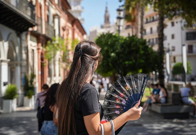Archivo - Una mujer abanica mientras pasea. A 05 de julio de 2024, en Sevilla (Andalucía, España). 