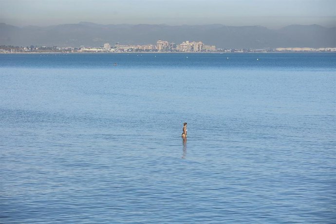 Archivo - Una persona se baña en la playa de la Malvarrosa en imagen de archivo