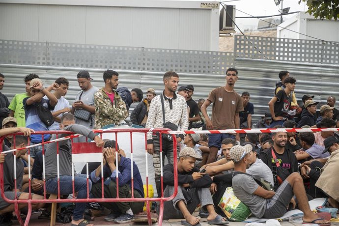 Decenas de migrantes esperan en las inmediaciones de la explanada del embolsamiento de Loma Colmenar, a 3 de septiembre de 2026, en Ceuta (España). La situación es de calma contenida después de que el pasado 2 de septiembre la Policía Nacional tuviera que