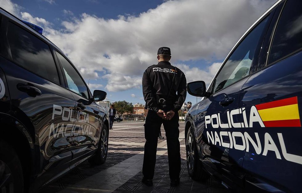 Archivo - Imagen de archivo de un agente de la Policía Nacional junto con vehículos oficiales