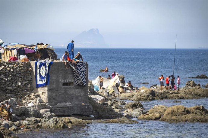 Varios migrantes asentados en la playa del Trampolín, a 31 de agosto de 2026, en Ceuta (España). L