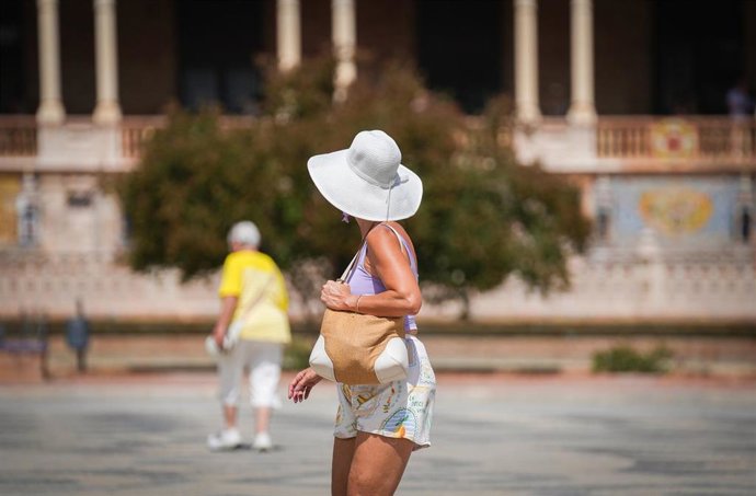 Una mujer con sombrero y ropa veraniega durante una jornada de intenso calor. A 03 de septiembre de 2026, en Sevilla (Andalucía, España). 
